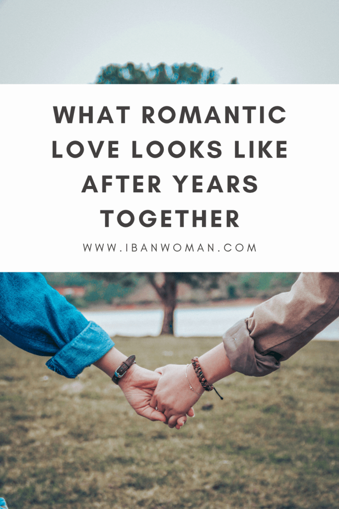 A couple holding hands in a quiet park, showing what romantic love looks like after years together